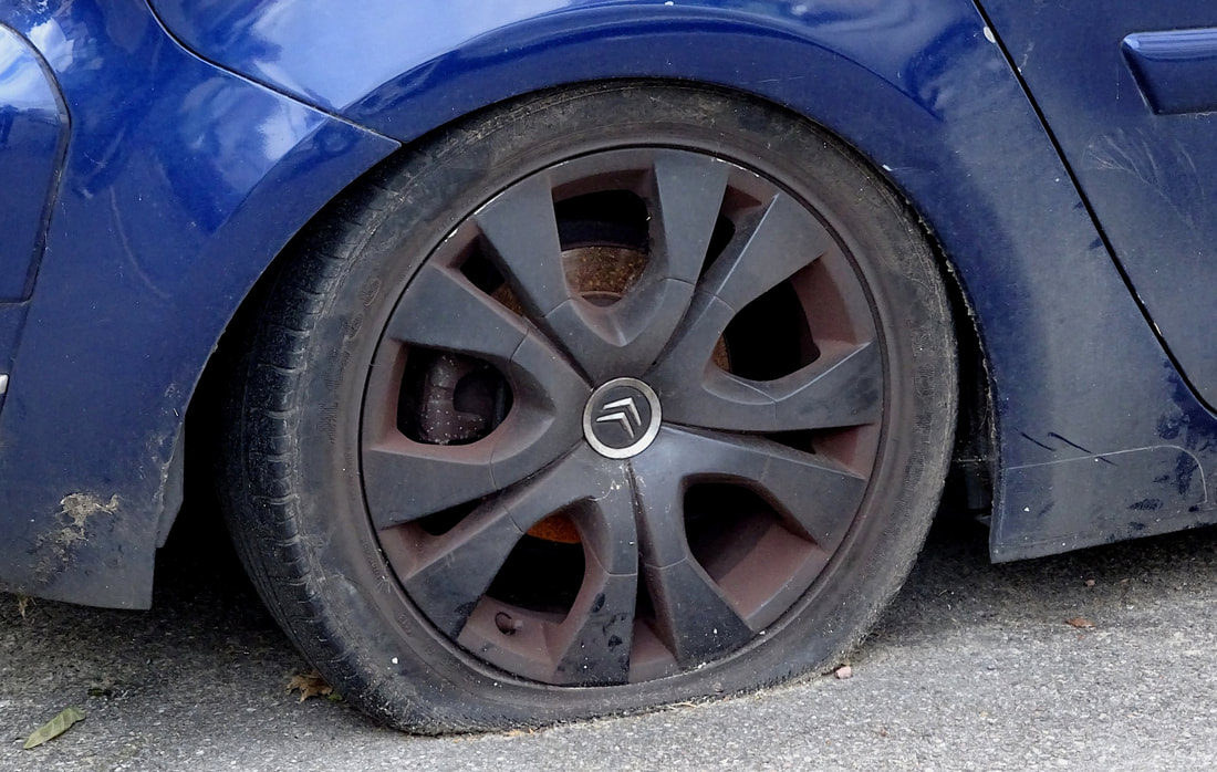 blue car with flat tire
